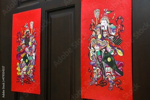 Chinese New Year Door Gods (Menshen) hung behind wooden door to protect against evil influences photo