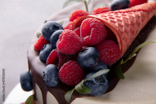 Close-up of berries with a waffle on a chocolate cake. Selective focus