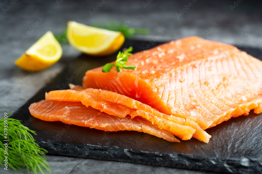 Fresh salmon fillet in a plate, top view. gray background.