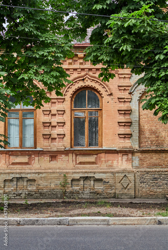Wall of yellow building with arched windows on summer day © glebchik