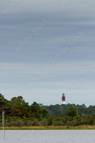 Chincoteague lighthouse standing above the trees guarding the beach on Chincoteague Island within Assateague National Seashore with an oncoming storm in the background. photo