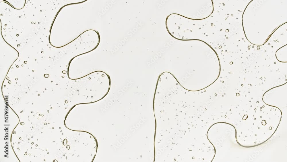 Transparent cosmetic gel fluid with bubbles oil on water silver colored background. Macro Shot. High quality 4k footage Transparent cosmetic gel fluid with bubbles oil on water silver colored background. Macro Shot. High quality 4k footage
