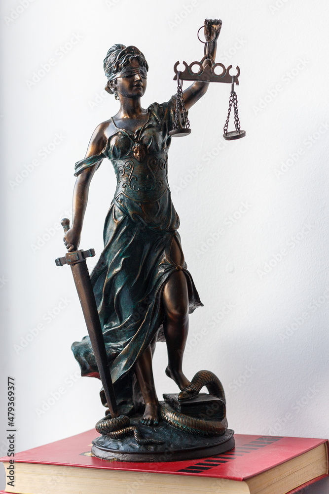 A figure of a temida with a scales in her hand, a sword and a blindfold - a symbol of the law A figure of a temida with a scales in her hand, a sword and a blindfold - a symbol of the law