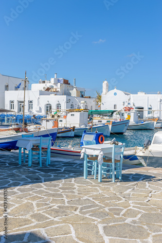 Traditional Cycladitic view with moored traditional fishing boats at the picturesque harbor of Naousa Paros, Greece.