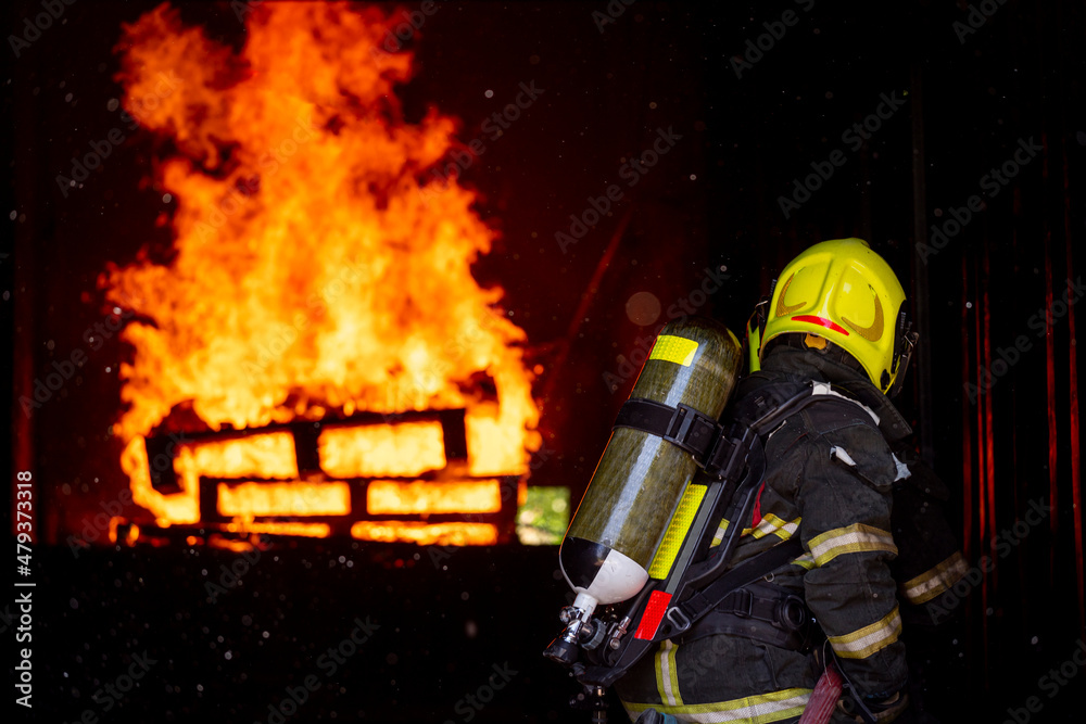 firefighters wearing fire fighter suit for safety and using twirl water extinguisher for fighting the fire flame in emergency situation.. - Safety Firefighter and industrial concept.