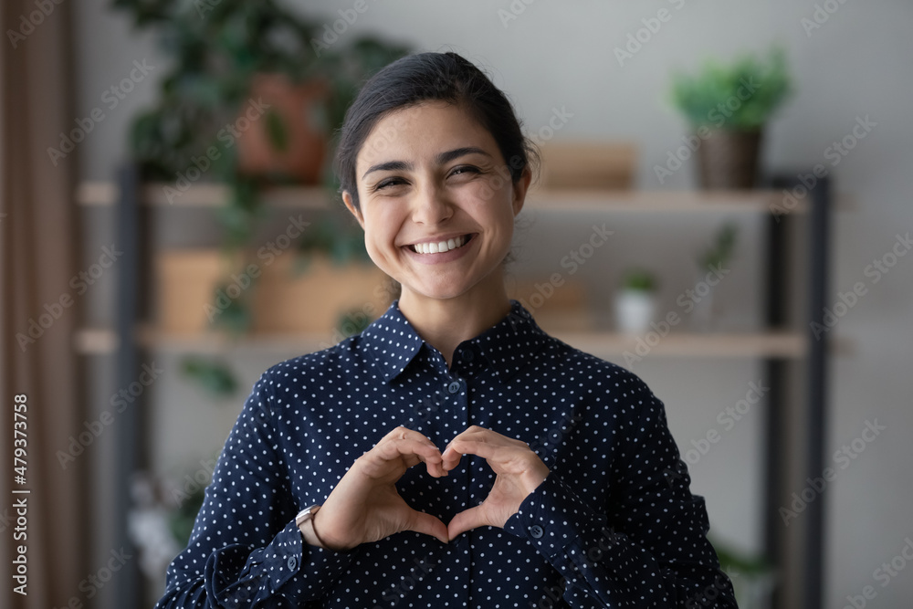 Φωτογραφία Happy millennial Indian woman making hand finger heart, showing love sign, like, smiling at camera