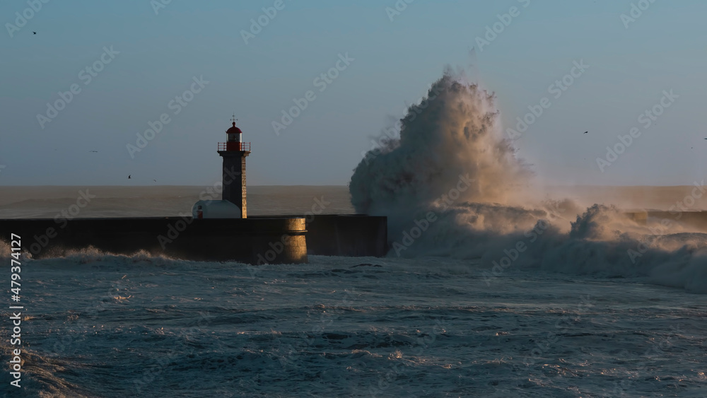 Lighthouse and huge wave on a beach Matosinhos at Atlantic ocean, Porto, Portugal.