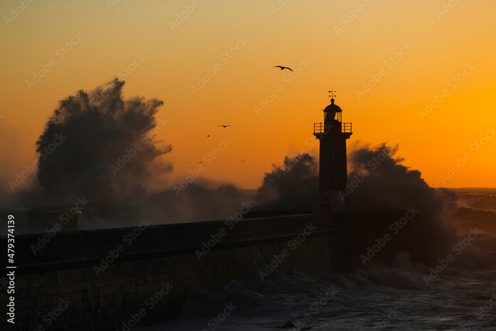 Huge wave on a beach Matosinhos in Porto with the lighthouse in the background. Atlantic osean, Portugal.