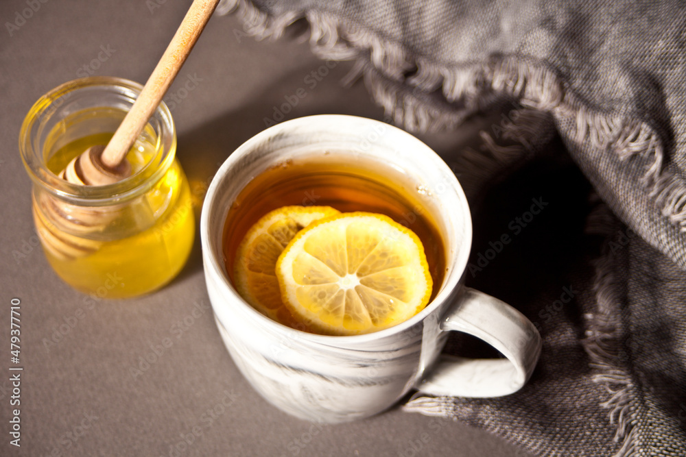 Hot tea with lemon and honey on the dark background Hot tea with lemon and honey on the dark background