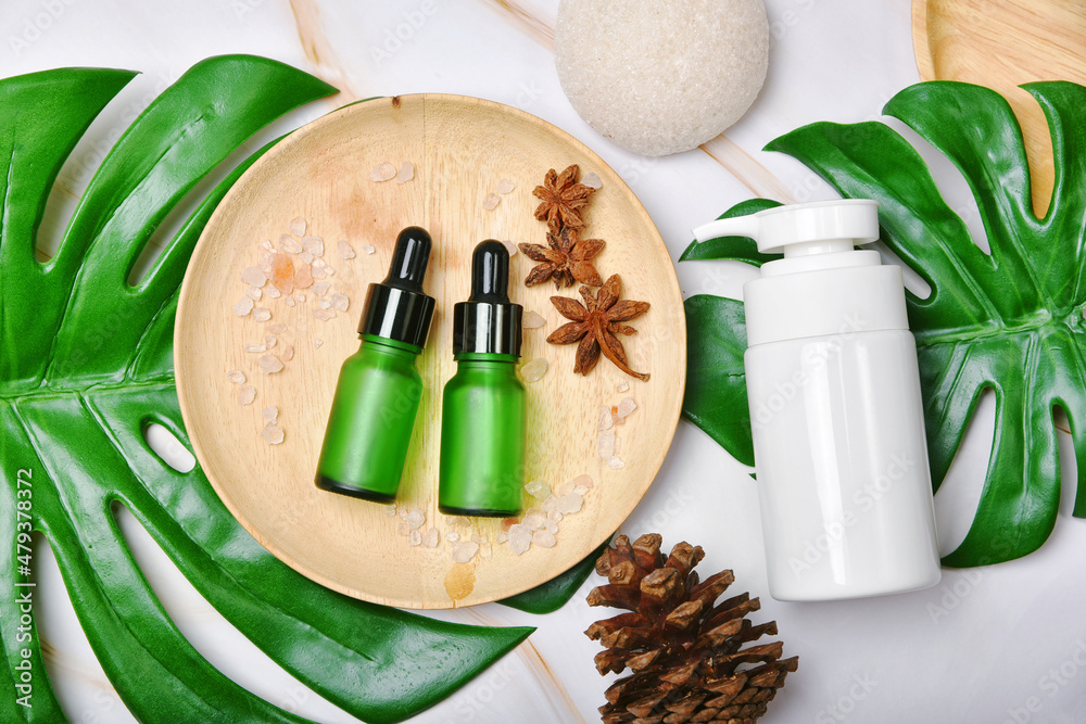 Natural skincare beauty product with spices oil, Cosmetic pump bottle containers packaging with green nature leaves, Blank label for organic spa branding mock-up,Herbal healthy skin care.
