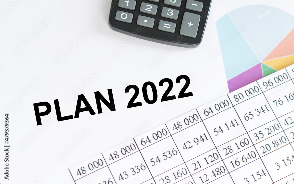 2022 plan text on notepad on the background of colored graphs and reports on the table 2022 plan text on notepad on the background of colored graphs and reports on the table