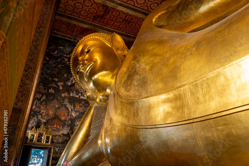 Reclining Buddha statue in Wat Pho, a famous Buddhist temple complex in Bangkok, Thailand. 