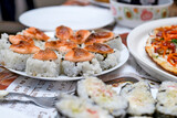 On a white plate, baked sushi on a festive table.