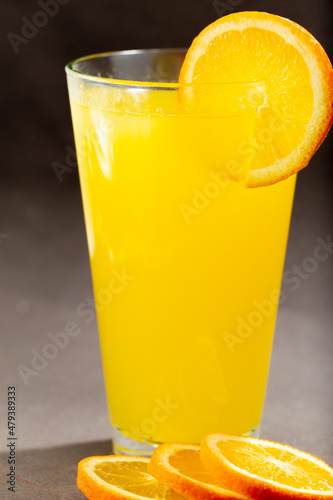 Glass of fresh orange juice with fruits cut in half and sliced isolated on gray background, clipping path