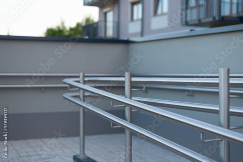 Stainless steel handrail on a ramp for disabled persons in modern housing area