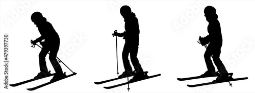 The skier stands half sideways, bending his knee. Winter sports. Female black silhouette isolated on white background. Woman skier. Girl in a ski suit with ski sticks in her hands and skis on her feet