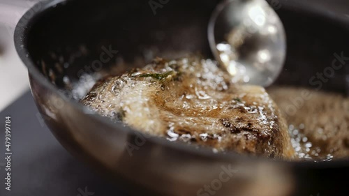 Professional chef cooks meat in a frying pan in a restaurant