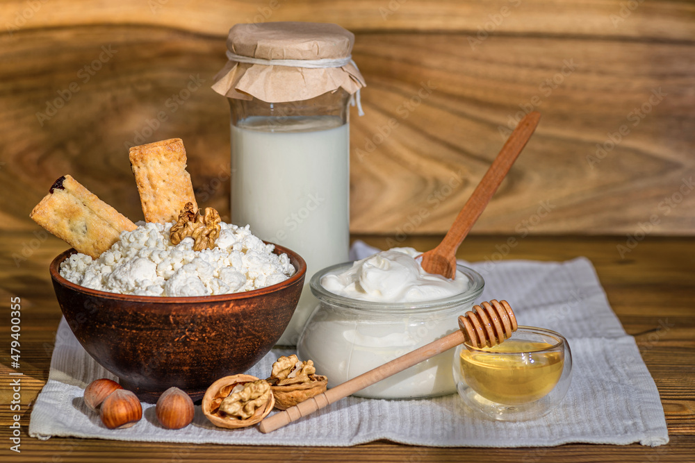 Bottles with milk, cheese, sour cream, butter on a wooden background. Farm organic fresh food. Dairy products Bottles with milk, cheese, sour cream, butter on a wooden background. Farm organic fresh food. Dairy products