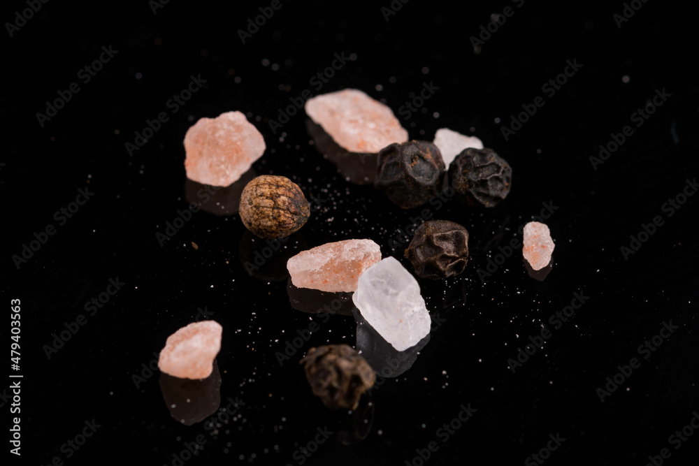 Naklejka premium himalayan salt with peppercorns on black background