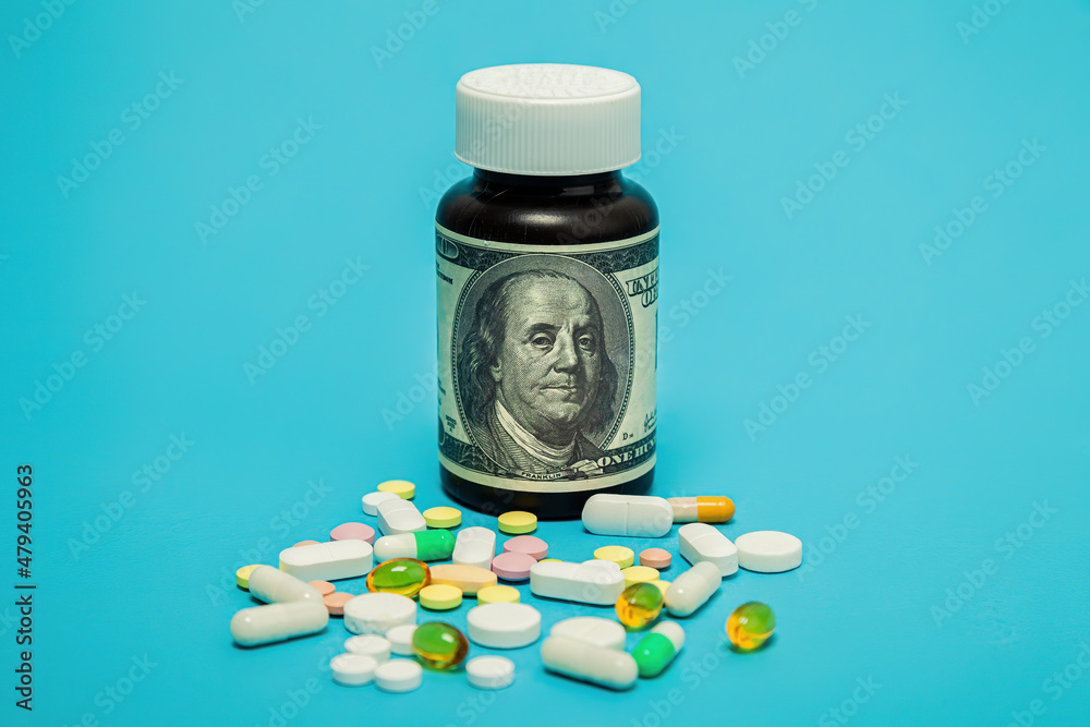 Money and pills of different colors on a blue background. The rise in the cost of medical care. The concept of insurance medicine, insurance, high cost, high cost of drugs. Money and pills of different colors on a blue background. The rise in the cost of medical care. The concept of insurance medicine, insurance, high cost, high cost of drugs.