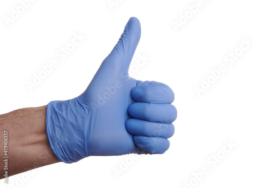 Thumb up hand gesture in blue nitrile glove. Nitrile gloved hand shows thumb up success gesture. Photo of medic gloved hand isolated on a white background. Positive gesture of medic hand. Blue nitrile