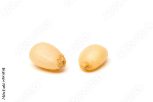 Siberian Peeled pine nuts isolated on white background. Healthy nuts snacks. Clipping path, full depth of field. Closeup view.