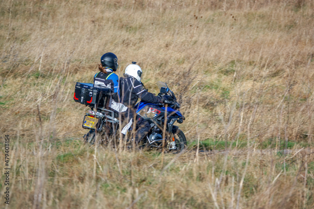 motorbike rider and pillion passenger on a BMW R1200 GS motorcycle travelling through winter countryside