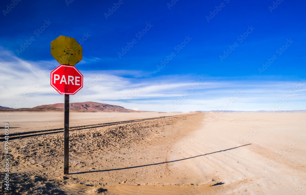 Stop sign next to old railway in Salar de Uyuni salt flat, Bolivia
