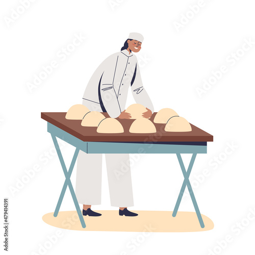 Woman baker kneading and rolling dough for baking bread. Female work in bakery production industry