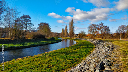 Schilderij op canvas River flows through artificial stream bed made of grass and stony embankment