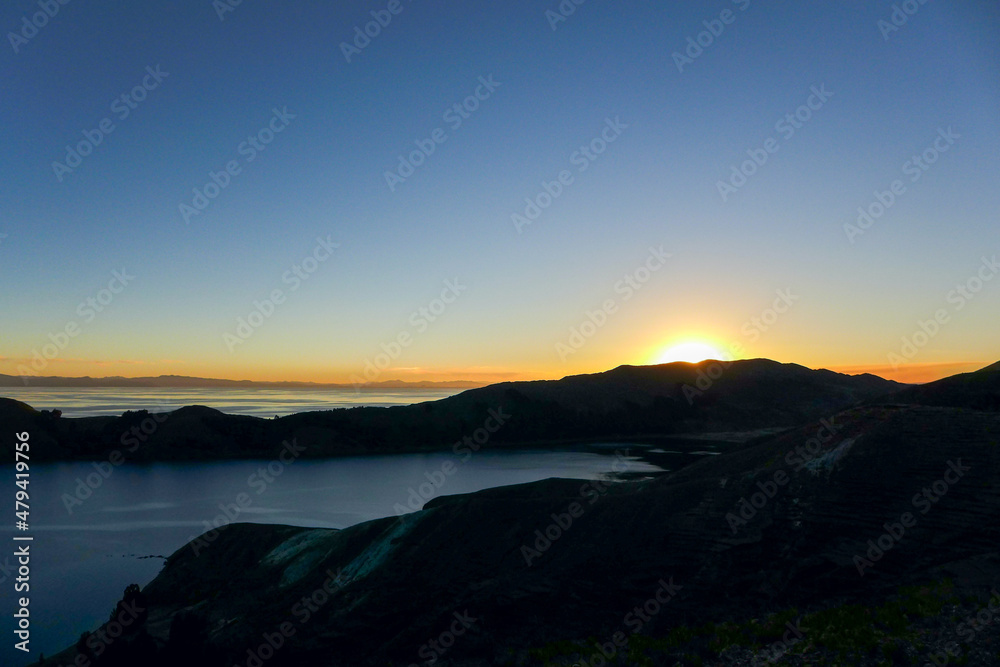 Beautiful sunset behind the silhouette of the mountains on the Isla del Sol with a clear, blue sky. Lake Titicaca - Bolivia