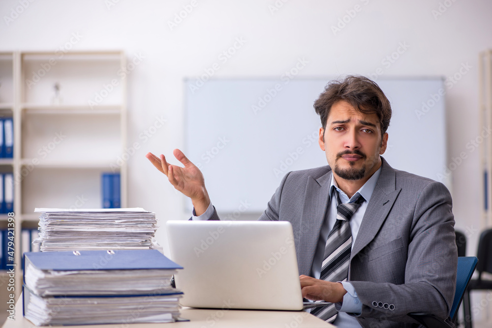 Young businessman employee and too much work in the office Young businessman employee and too much work in the office