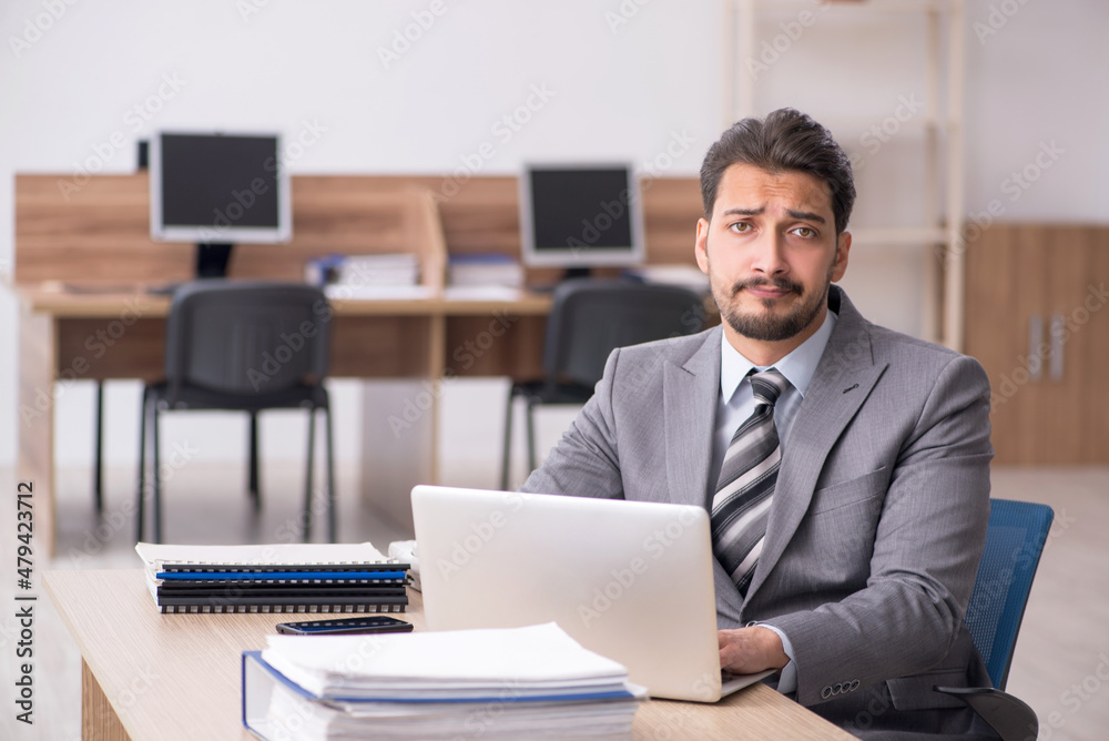 Young male employee working in the office Young male employee working in the office