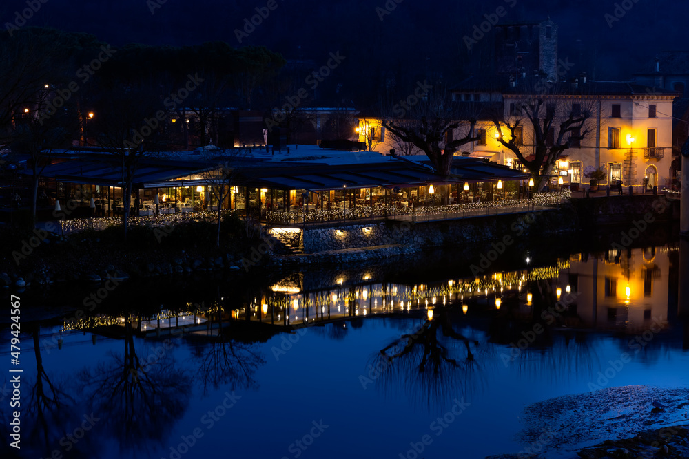 night view of Borghetto (Valeggio sul Mincio, Verona), reflexe on the river of a restaurant at night