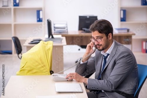 Young male employee looking after new born at workplace