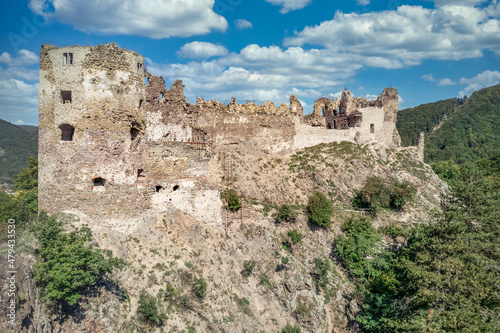 Aerial summer view of Sasov castle in Slovakia above the Hron river with circular donjon tower and partially restored walls on a hilltop photo
