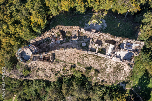 Aerial view of Sasovsky Hrad or Castle in central Slovakia above the Hron river with circular gate tower and adjacent  palace building on a steep mountain top photo