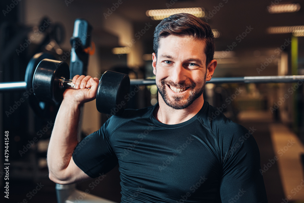 happy easy lifting of dumbbell at gymnasium looking forward to get fit and muscular happy easy lifting of dumbbell at gymnasium looking forward to get fit and muscular