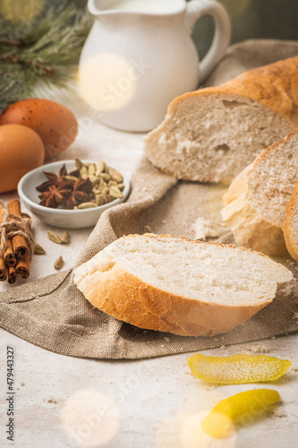 Ingredients for preparing spanish torrijas, french toasts or traditional Portuguese rabanadas. Typical christmas food made with bread, eggs, cinnamon, cardamom, anise star, milk and lemon peel