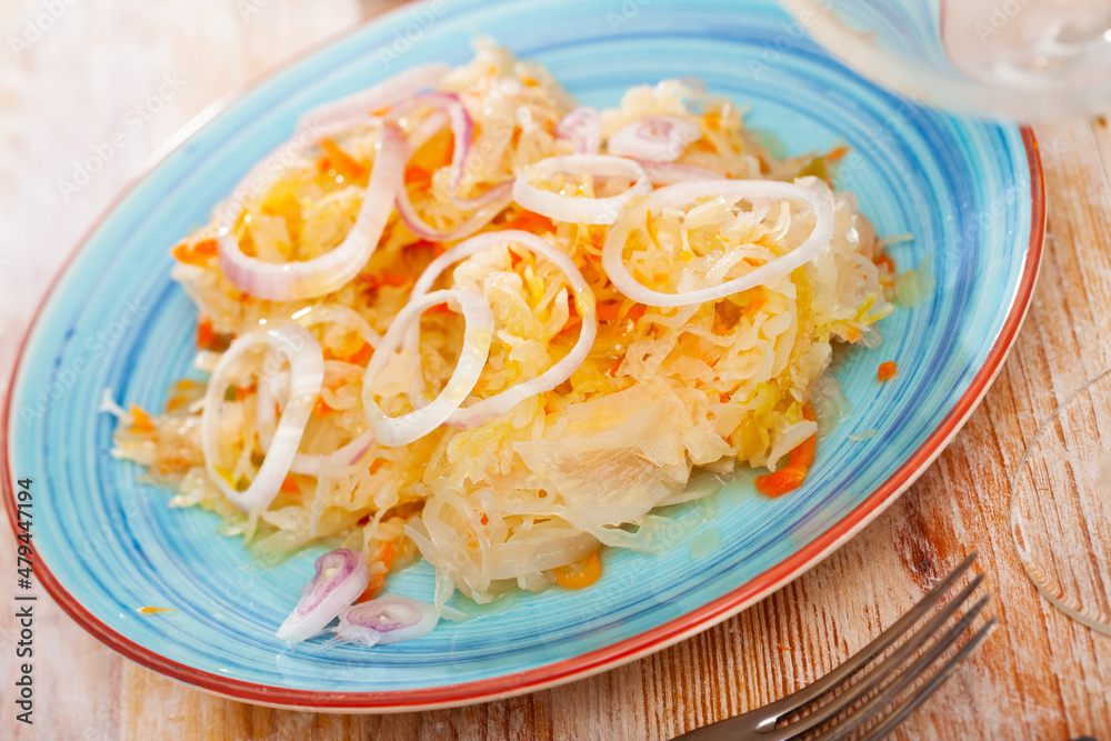 Plate with traditional Russian salted cabbage sauerkraut with onion, nobody