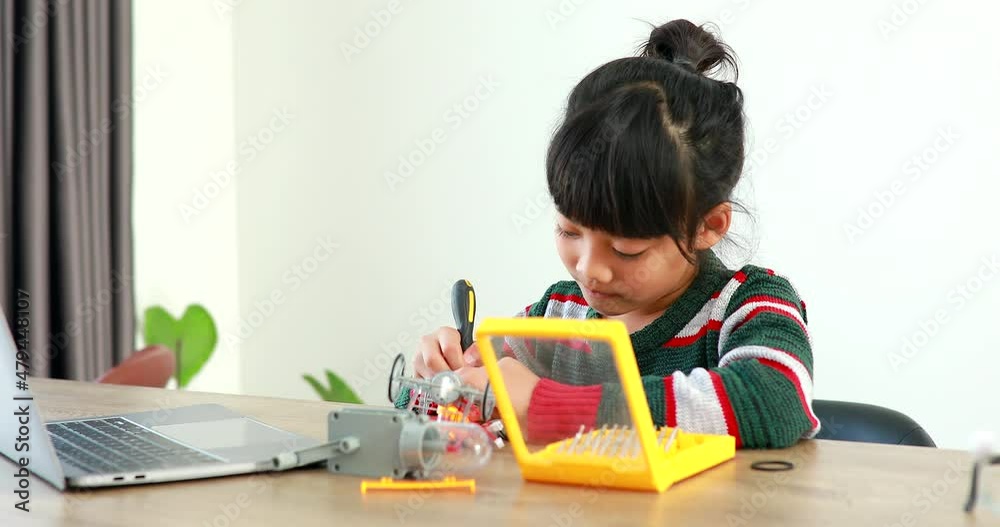 The little girl asian building robotic car in science lesson in the house . Which increases the development and enhances learning skills gifted brilliant children working with technology. The little girl asian building robotic car in science lesson in the house . Which increases the development and enhances learning skills gifted brilliant children working with technology.