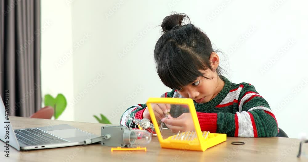 The little girl asian building robotic car in science lesson in the house . Which increases the development and enhances learning skills gifted brilliant children working with technology. The little girl asian building robotic car in science lesson in the house . Which increases the development and enhances learning skills gifted brilliant children working with technology.