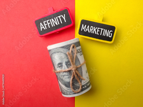 Fotografia Banknotes and colored board with text AFFINITY MARKERTING on colored background