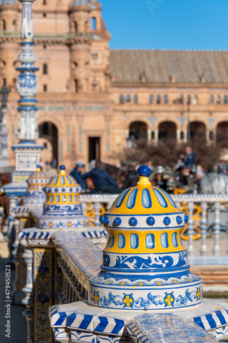 Close up of the colorful blue yellow and white ceramic lamp posts and railings inside the Plaza de Espana public park in Seville, Spain. photo