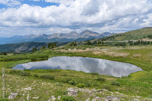 Summer Mountain Pond -  A panoramic view of a small pond at summit of Cottonwood Pass, surrounded by high peaks of Sawatch Range, on a calm Summer day. Buena Vista - Crested Butte, Colorado, USA. photo