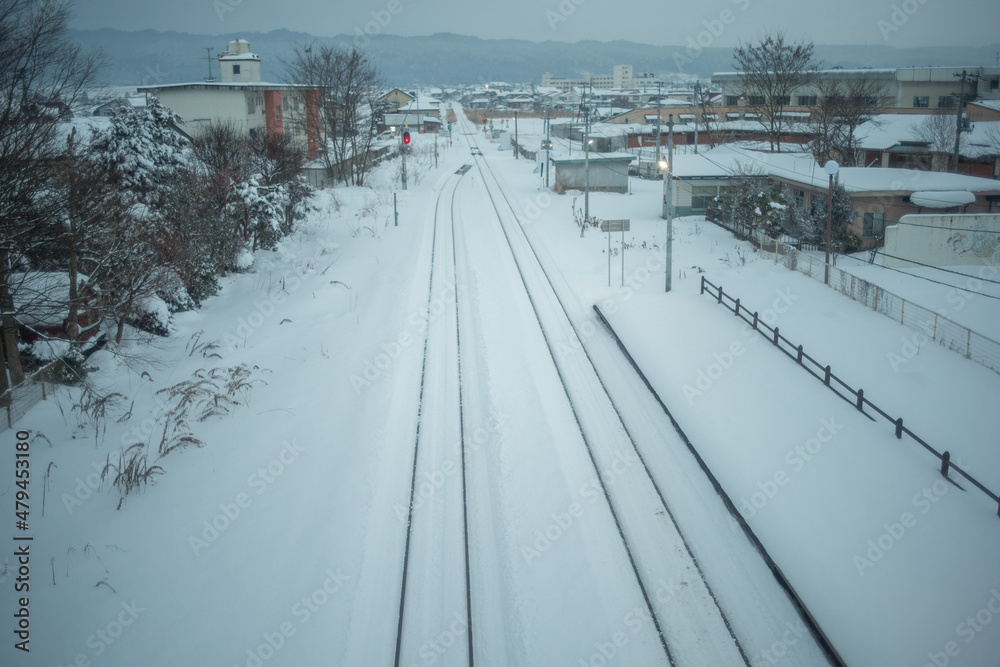 Obraz premium 雪の積もった線路と街の景色