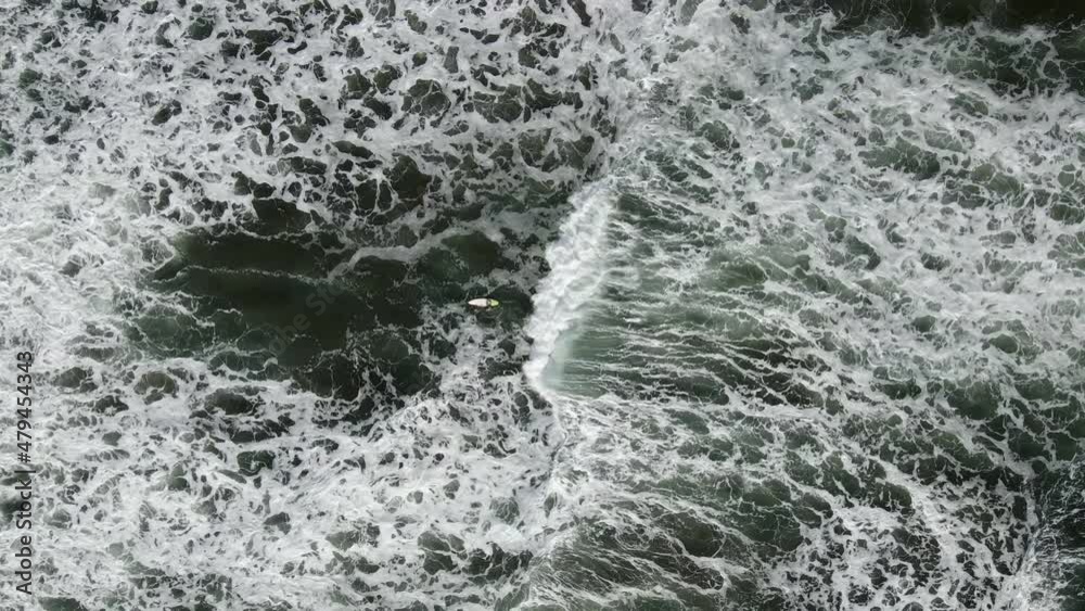 Drone pulls away from lone surfer to reveal vast textured waves Drone pulls away from lone surfer to reveal vast textured waves