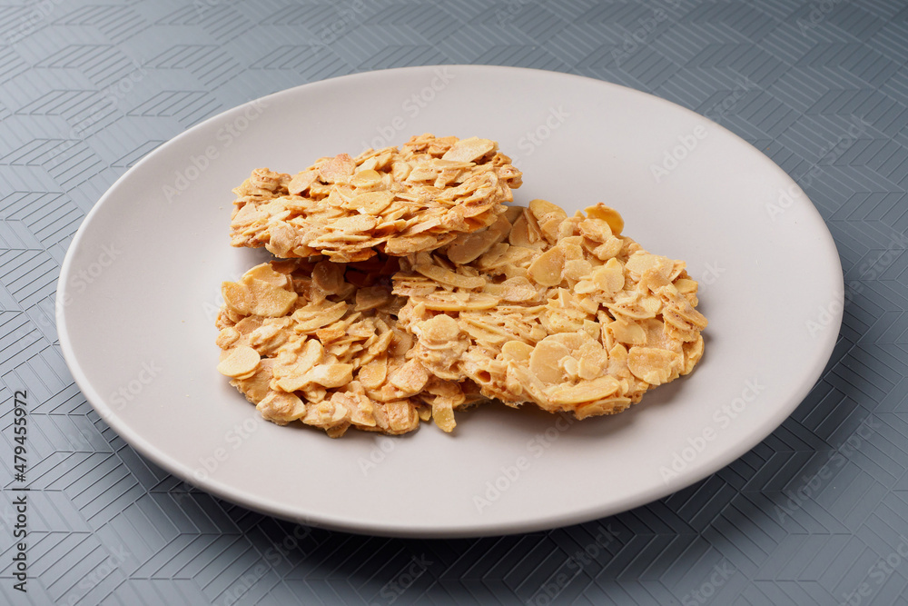 Florentina's macaroons. Almond petal cookies on a plate. Gray background. Florentina's macaroons. Almond petal cookies on a plate. Gray background.