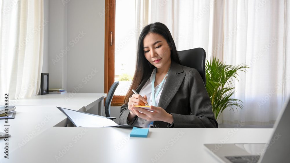 Business woman reading a document and taking a memo notes Business woman reading a document and taking a memo notes