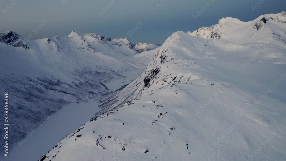 Slow flight over Arctic mountain range during mid-winter. In northern Norway, the sun never rises above the horizon., Creating a magical blue light. Slow flight over Arctic mountain range during mid-winter. In northern Norway, the sun never rises above the horizon., Creating a magical blue light.